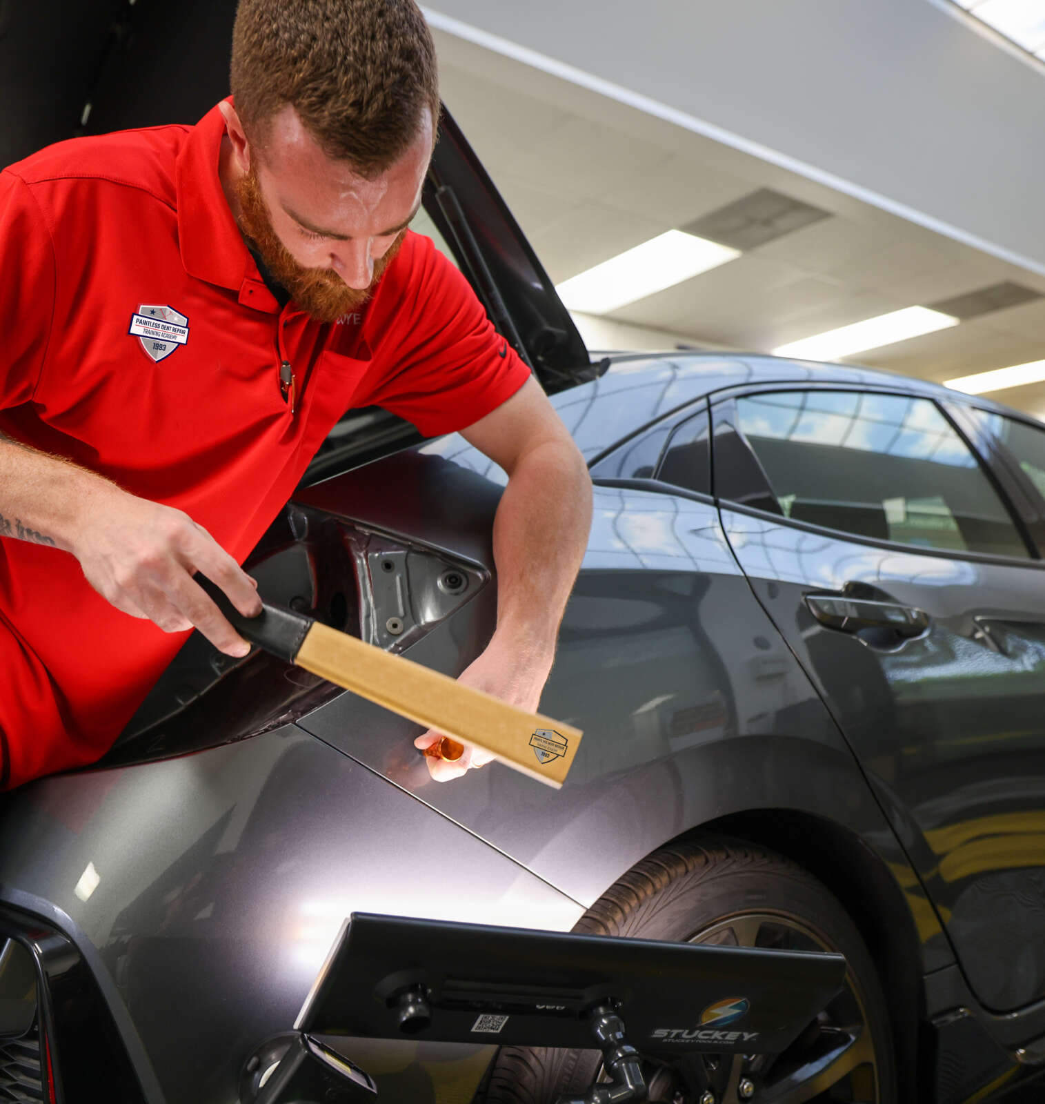 A man undergoing paintless dent repair training.